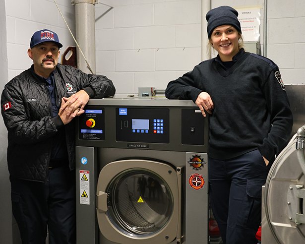 Clarington firefighters stand with the gear extractor.