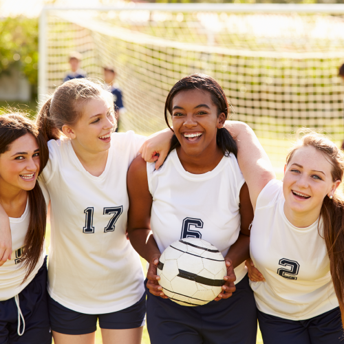 Diverse soccer team smiling together.