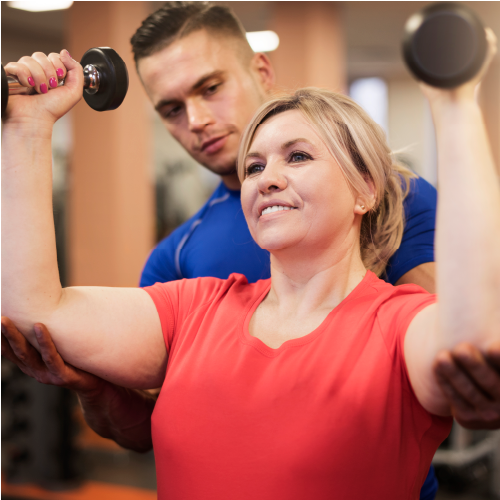 Personal trainer helping a client lift weights