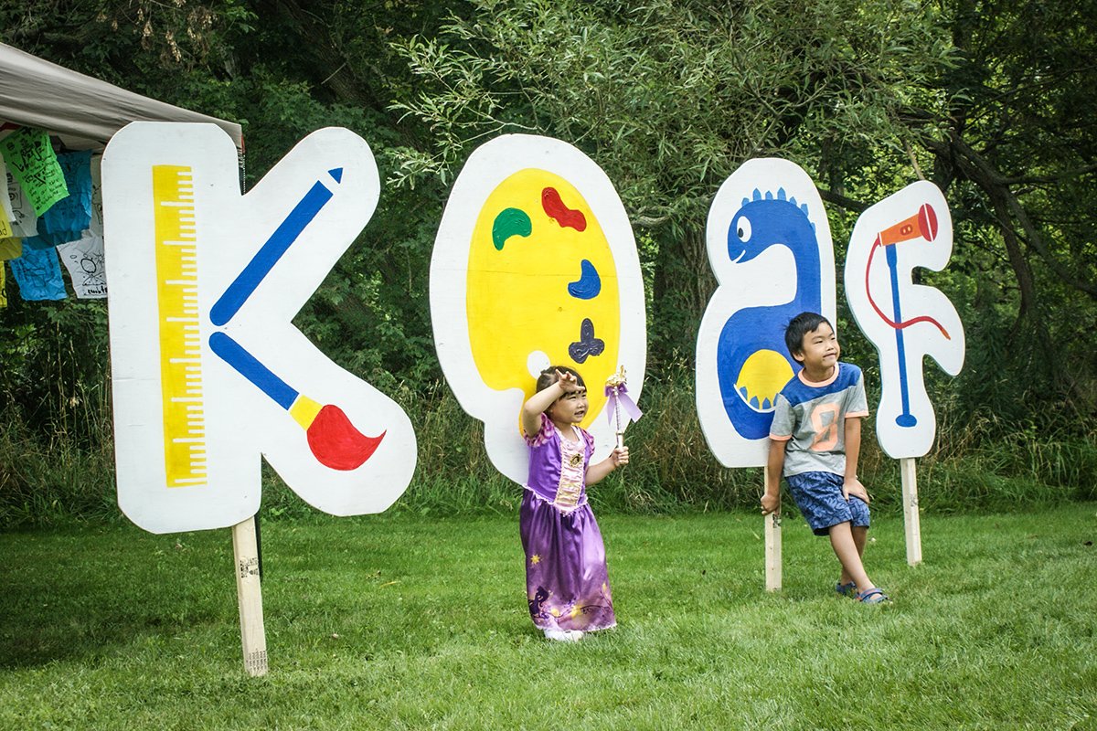 Kids Art Festival sign with children in front