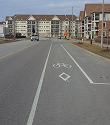 Dedicated bike lane signage and pavement markings with on-street parking