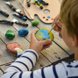 Boy painting rocks in the park