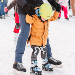 Parent and child skating together.