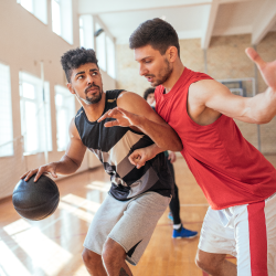 Two adults playing basketball