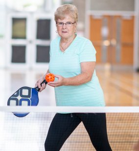 Woman serving a pickleball