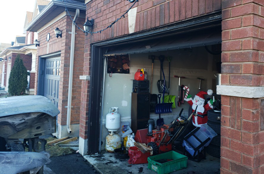 A burned garage showing improperly stored propane tanks
