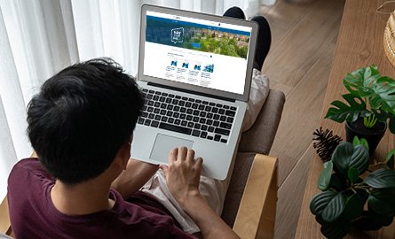 Man in a lounge chair with a laptop on the Clarington Connected website.