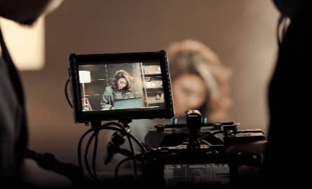 A film camera pointed at a woman during film production