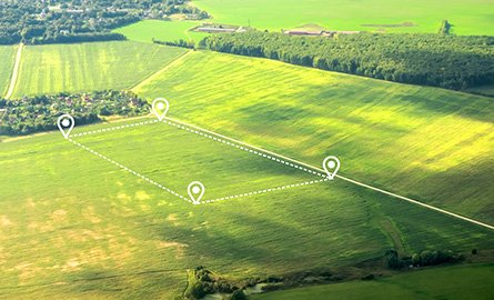Aerial view of green field, position point and boundary line to show an area of land being severed from a larger property.