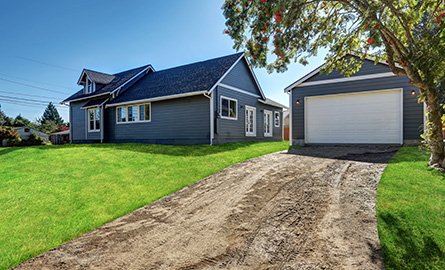 Backyard view of blue siding house with detached garage.