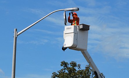 A worker changing a streetlight bulb