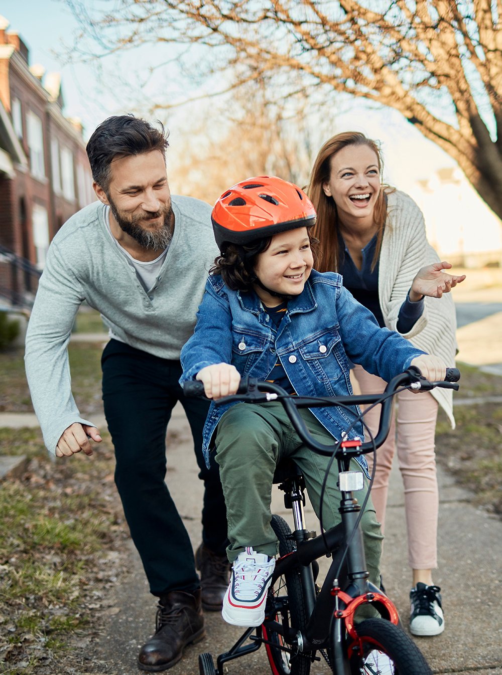 Happy family biking down the street.