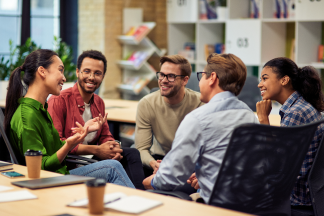 Group of young happy multi racial business people communicating and sharing ideas while working together in the modern office