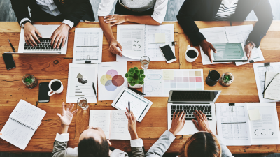 Overhead of colleagues having a meeting in modern office. 