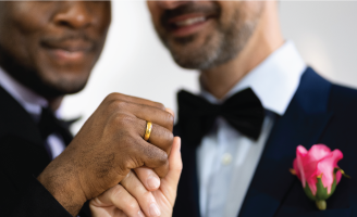 Two grooms holding hands on their wedding day.