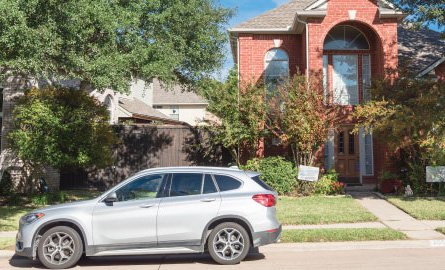 Car parked on the street in front of a home.