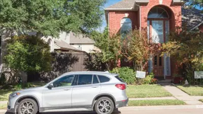 Car parked on the street in front of a home.