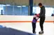 Father holding the hands of his daughter while skating.