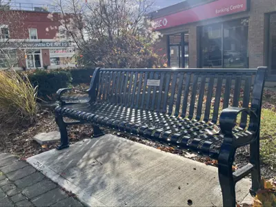 Picture of park bench with a bouquet of flowers on it.