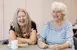 Two 55+ Woman playing dominoes.