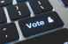 Close up of a key board with the enter button replaced by a vote button.