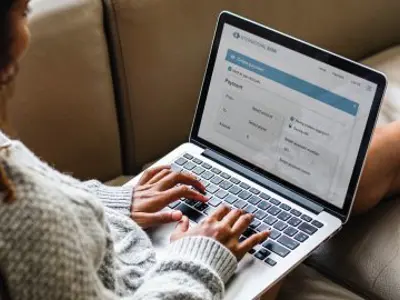 Woman banking on a laptop.