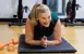 55+ woman doing a plank and smiling during a Clarington fitness class.