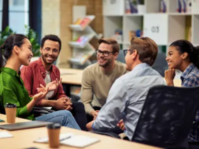 Group of young happy multi racial business people communicating and sharing ideas while working together in the modern office.