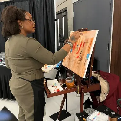 Artist Leequette (Lala) Santiago from Santiago Studios paints live during the event.